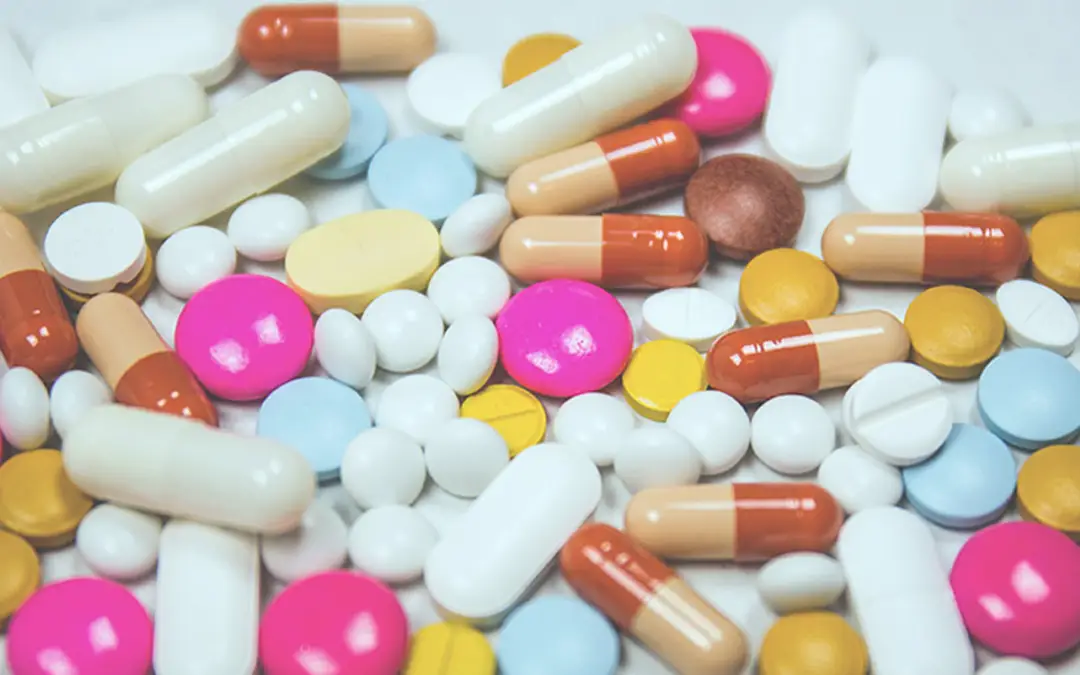 The Advantages of ‘Biosimilar’ Drugs | A bunch of different pills spread out over a table - Benefits Alliance