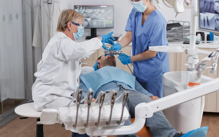 Drivers for Cutting Dental Costs | Odontologist performing a procedure on a patient - Benefits Alliance