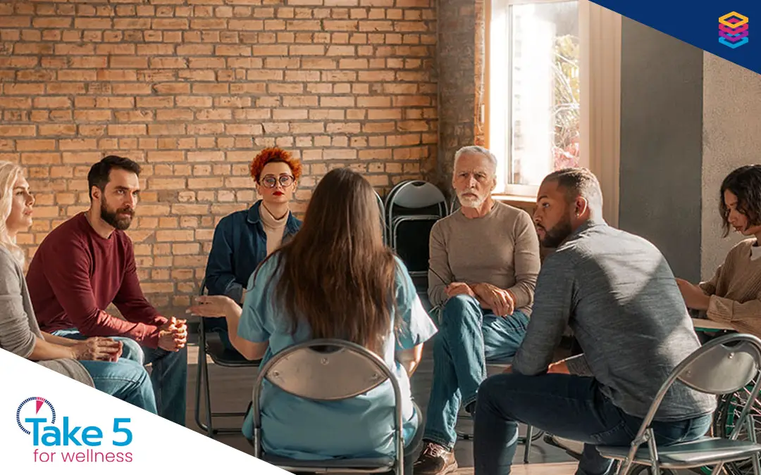 Closing a gap in mental health | Group of people talking to each other in a meeting - Benefits Alliance