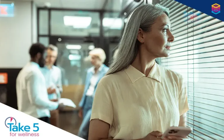 Helping bridge the women’s health gap | Older woman looking out a window with colleagues behind her - Benefits Alliance