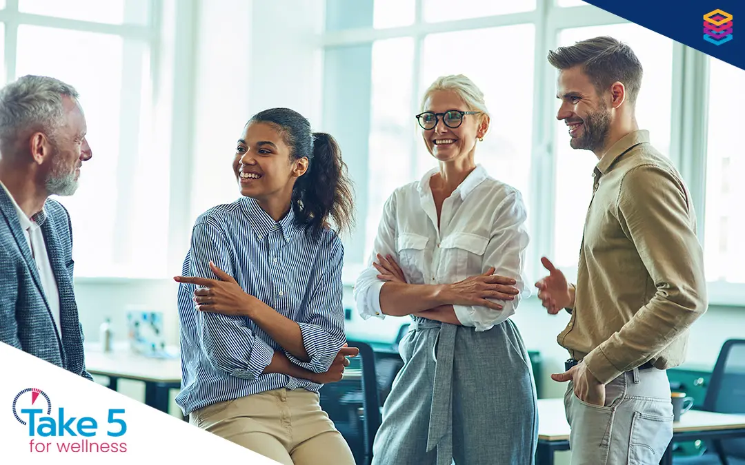 Doing good by doing wellness right | A group of coworkers from different age groups chatting with each other - Benefits Alliance