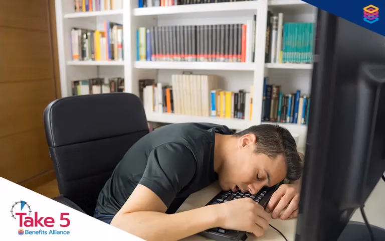 The eye-opening truth about poor sleep | Young office worker asleep at his desk - Benefits Alliance